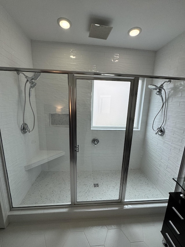 bathroom with a shower with shower door and tile patterned floors