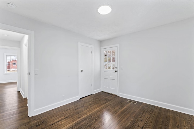 unfurnished room with dark hardwood / wood-style flooring