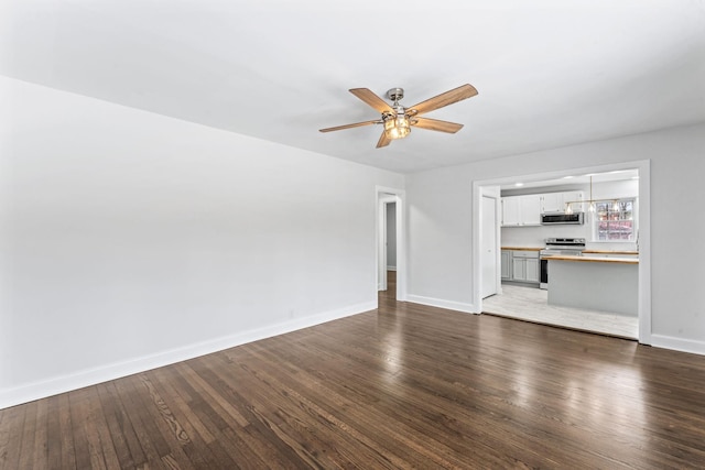 unfurnished living room featuring ceiling fan and dark wood-type flooring