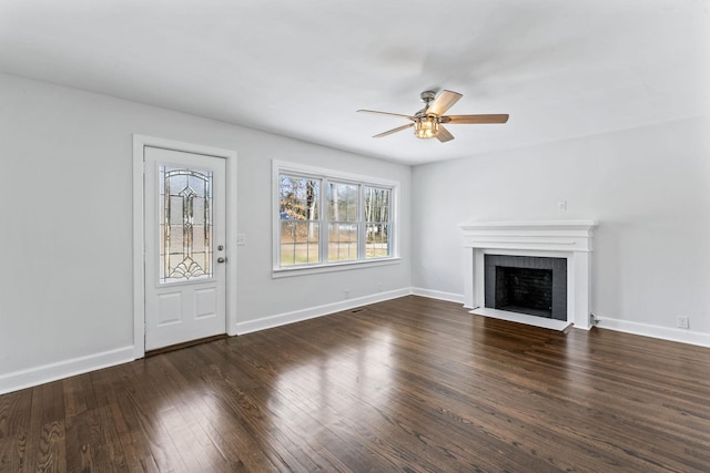 unfurnished living room featuring a brick fireplace, ceiling fan, and dark hardwood / wood-style floors