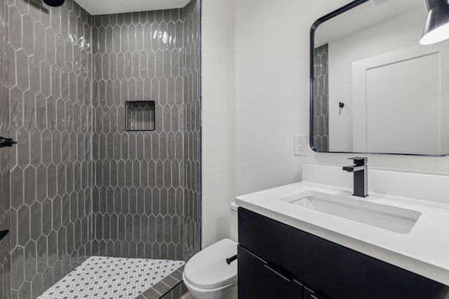 bathroom featuring vanity, toilet, and walk in shower