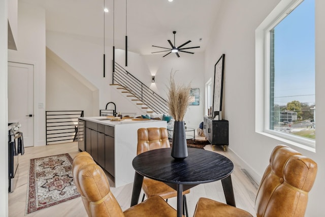 dining room with light hardwood / wood-style flooring, ceiling fan, and sink