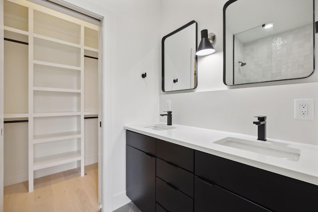 bathroom featuring vanity, wood-type flooring, and walk in shower