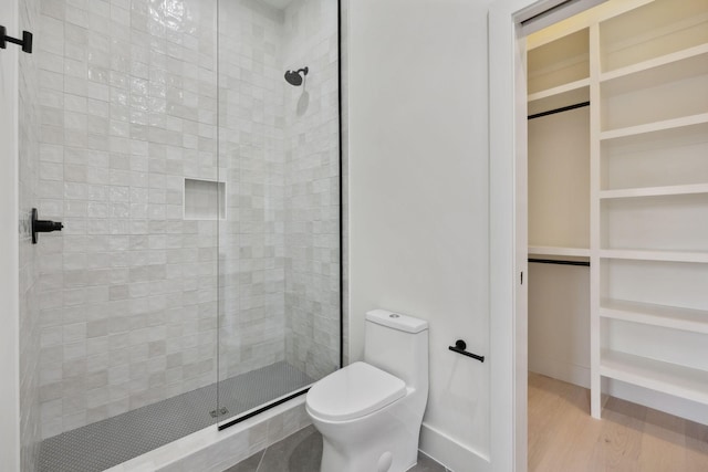 bathroom with wood-type flooring, toilet, and walk in shower