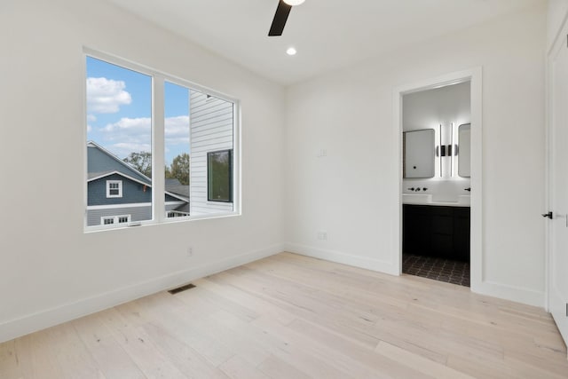 unfurnished bedroom featuring ensuite bath, ceiling fan, and light hardwood / wood-style flooring