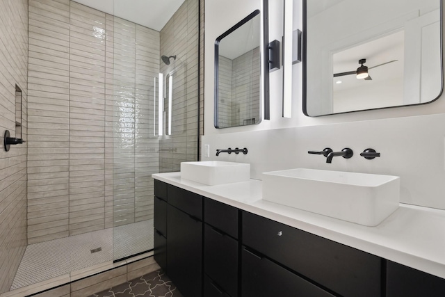 bathroom featuring tile patterned flooring, vanity, and a tile shower