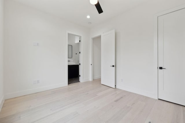 unfurnished bedroom with ceiling fan, light wood-type flooring, and connected bathroom