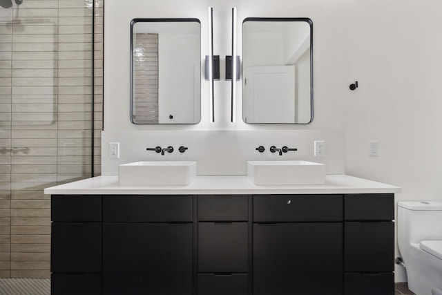 bathroom featuring tiled shower, vanity, and toilet