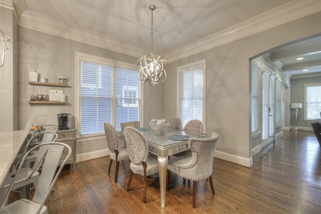 dining space with dark hardwood / wood-style flooring, an inviting chandelier, and crown molding