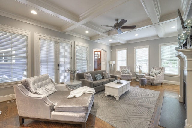 living room featuring dark hardwood / wood-style flooring, ornamental molding, coffered ceiling, ceiling fan, and beam ceiling