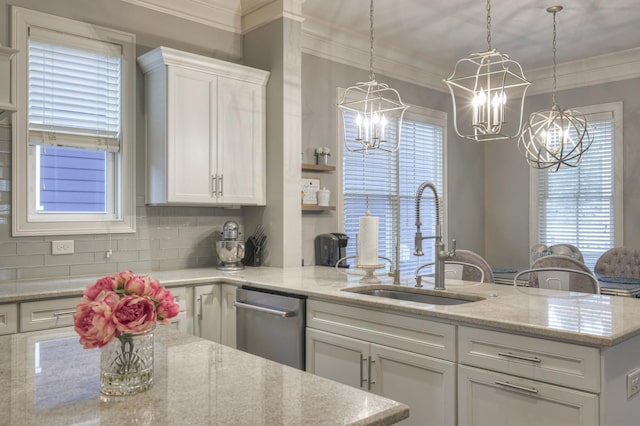 kitchen featuring sink, ornamental molding, decorative light fixtures, light stone counters, and white cabinetry