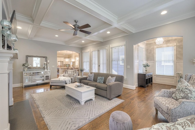 living room featuring beamed ceiling, ceiling fan with notable chandelier, and coffered ceiling