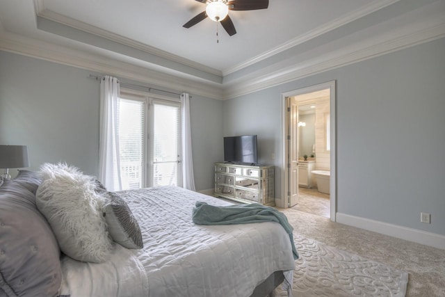 carpeted bedroom featuring a raised ceiling, connected bathroom, ceiling fan, and ornamental molding