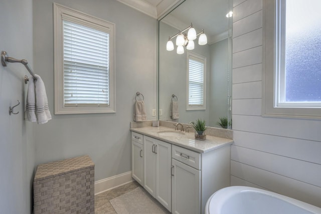 bathroom with a healthy amount of sunlight, vanity, tile patterned floors, and crown molding