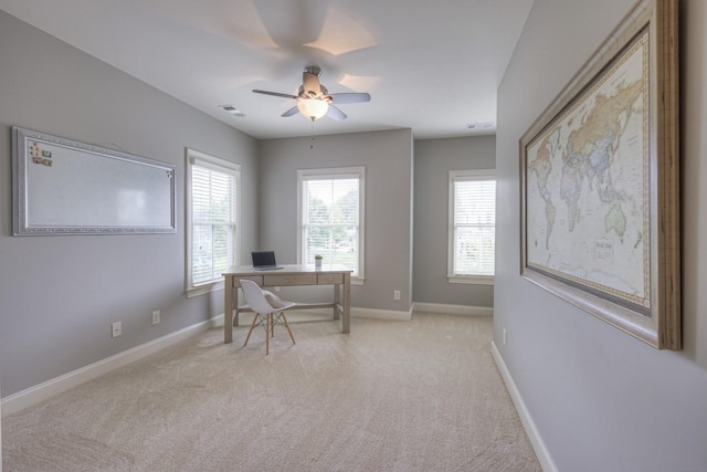 carpeted office space featuring ceiling fan