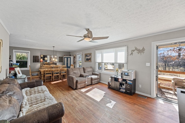 living room featuring hardwood / wood-style flooring, ornamental molding, a wealth of natural light, and ceiling fan