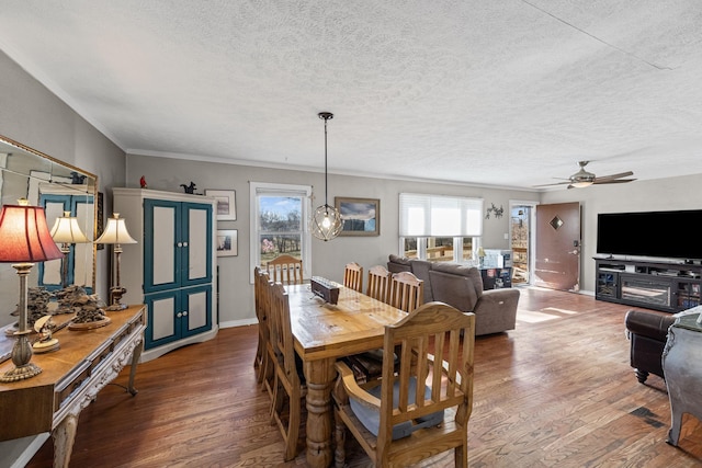 dining space with ceiling fan, wood-type flooring, and a textured ceiling