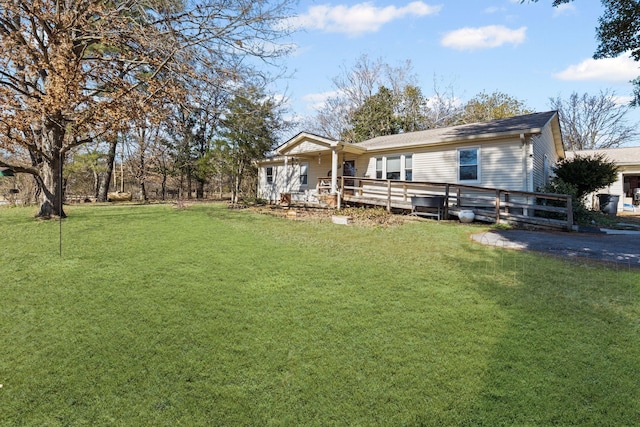 back of property with a deck and a lawn