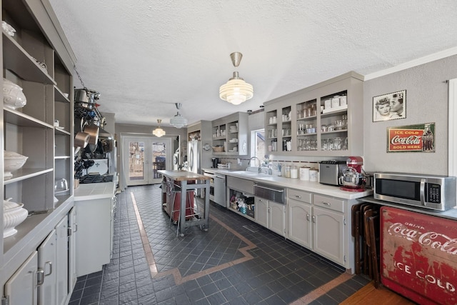 kitchen featuring appliances with stainless steel finishes, a textured ceiling, light countertops, and open shelves