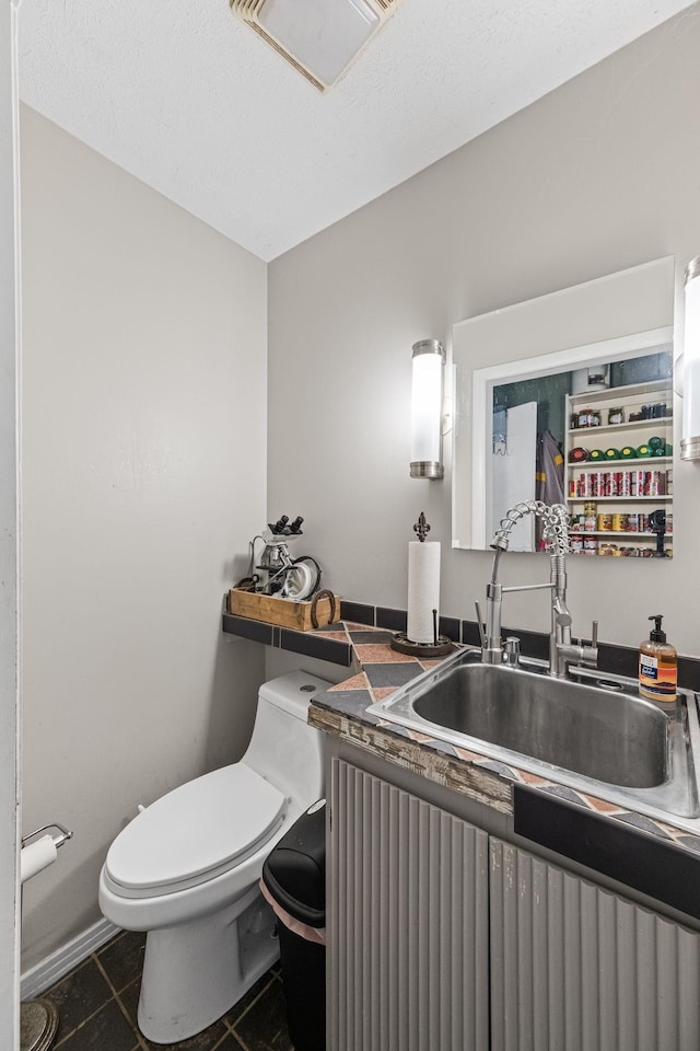 bathroom with tile patterned flooring, vanity, and toilet