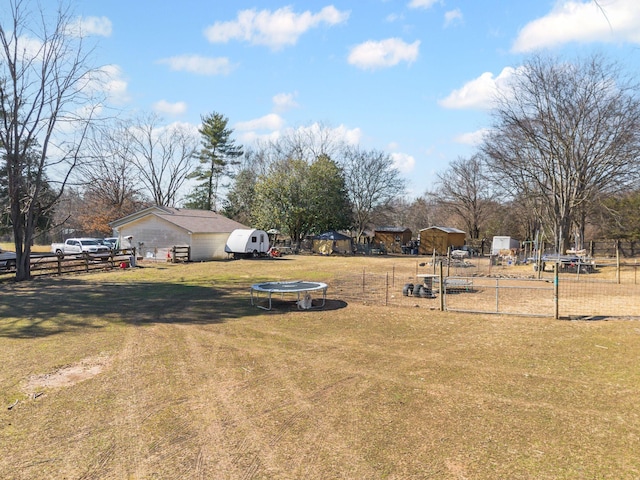 view of yard with a trampoline and fence