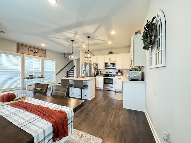 bedroom with stainless steel refrigerator with ice dispenser and dark hardwood / wood-style floors