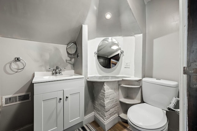 bathroom with hardwood / wood-style floors, vanity, and toilet