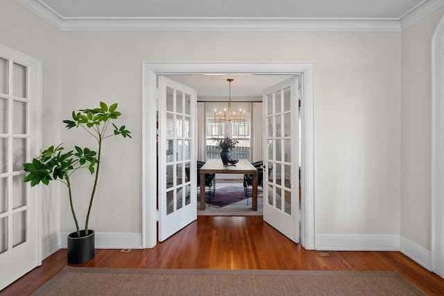 dining area featuring an inviting chandelier, crown molding, and french doors