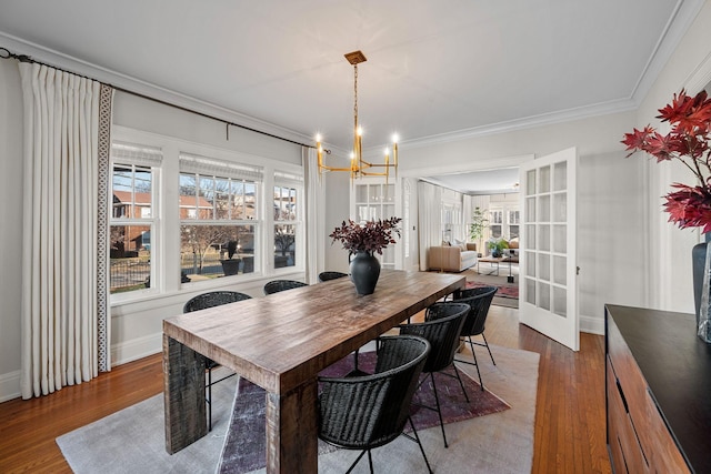 dining room featuring a chandelier, hardwood / wood-style floors, french doors, and ornamental molding