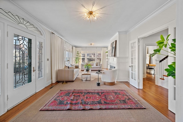 living room featuring crown molding, french doors, and hardwood / wood-style flooring