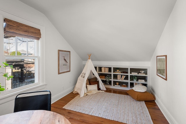 rec room featuring hardwood / wood-style flooring, lofted ceiling, and built in features