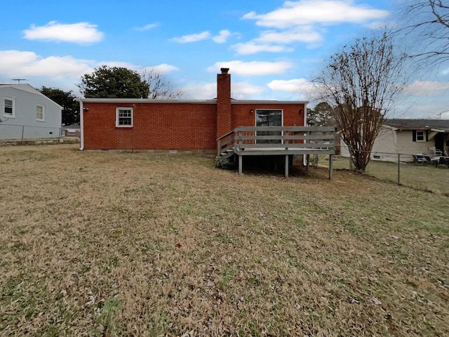 back of property with a yard and a wooden deck