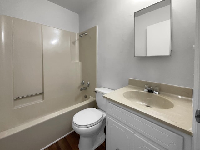 full bathroom with hardwood / wood-style flooring, toilet, vanity, and washtub / shower combination