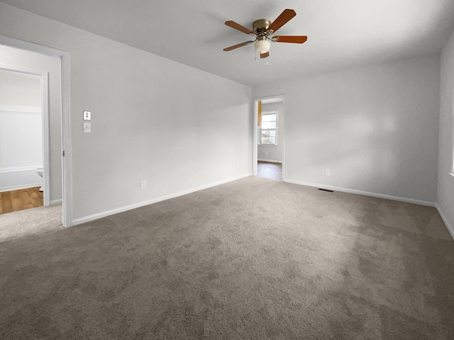 carpeted spare room featuring ceiling fan