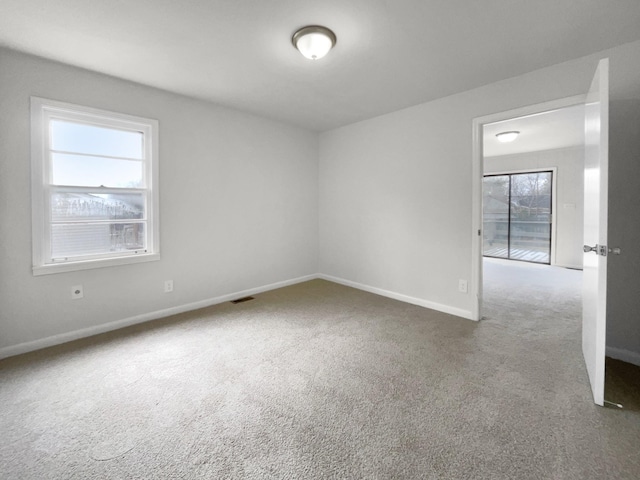 unfurnished room featuring carpet flooring and plenty of natural light