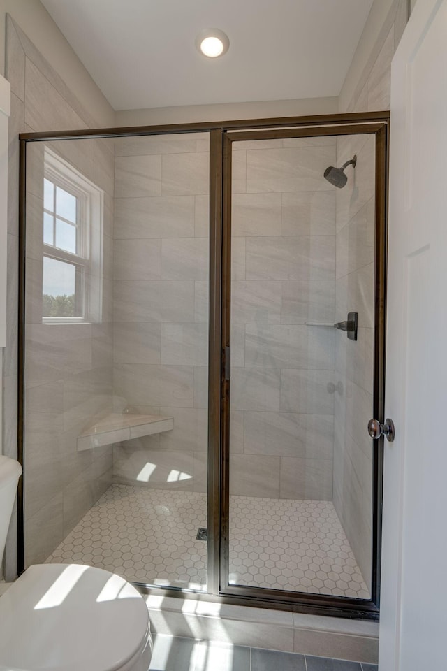 bathroom featuring toilet and an enclosed shower