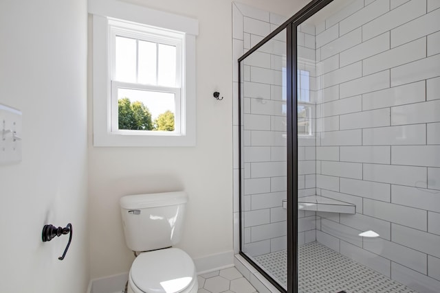 bathroom featuring tile patterned floors, toilet, and a shower with shower door