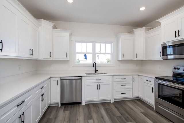 kitchen featuring dark hardwood / wood-style floors, sink, white cabinetry, and stainless steel appliances