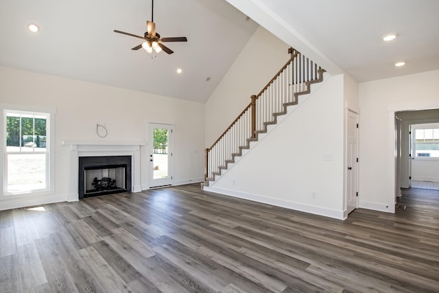 unfurnished living room featuring ceiling fan, dark hardwood / wood-style flooring, and high vaulted ceiling