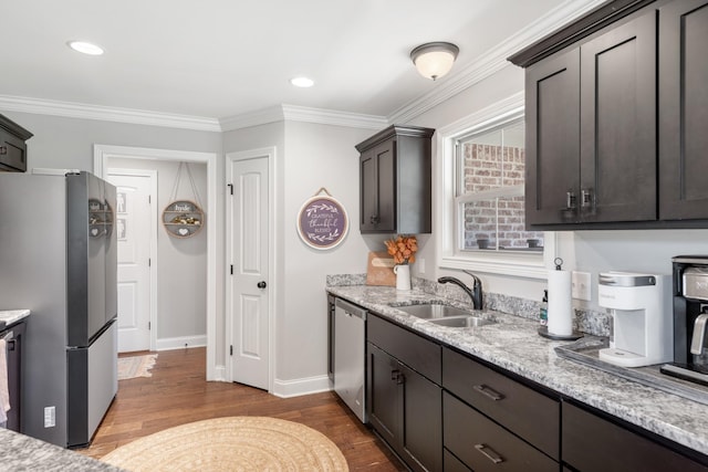 kitchen with crown molding, sink, appliances with stainless steel finishes, dark brown cabinets, and wood-type flooring