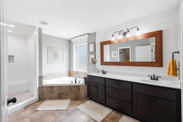 bathroom featuring vanity and independent shower and bath