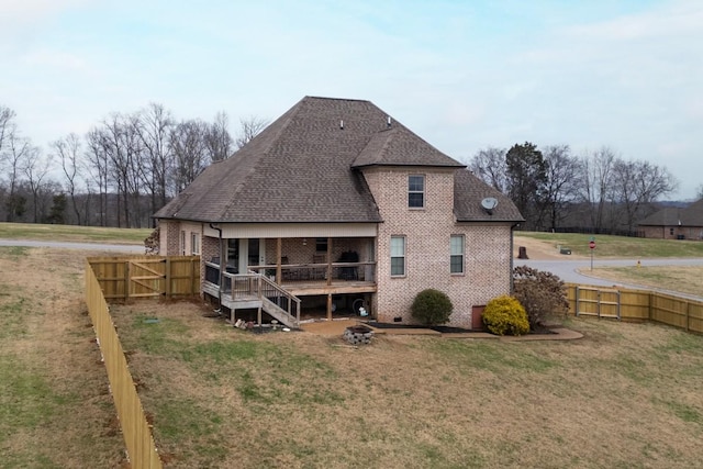 back of property featuring a lawn and a deck