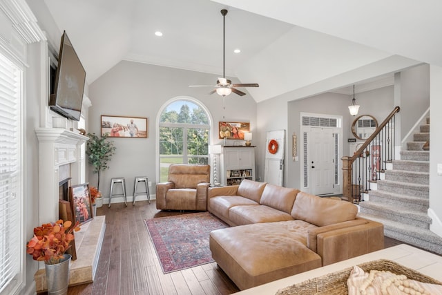 living room with ceiling fan, dark hardwood / wood-style floors, lofted ceiling, and a tile fireplace