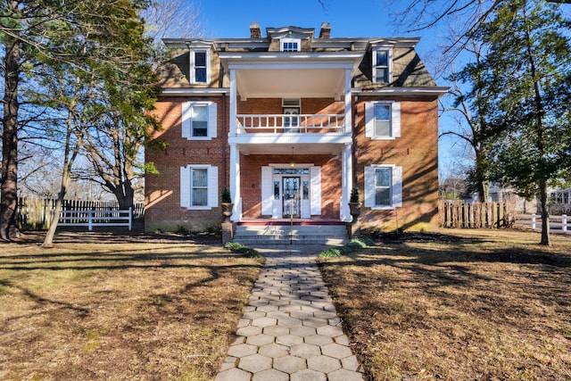 view of front facade with a front lawn and a balcony