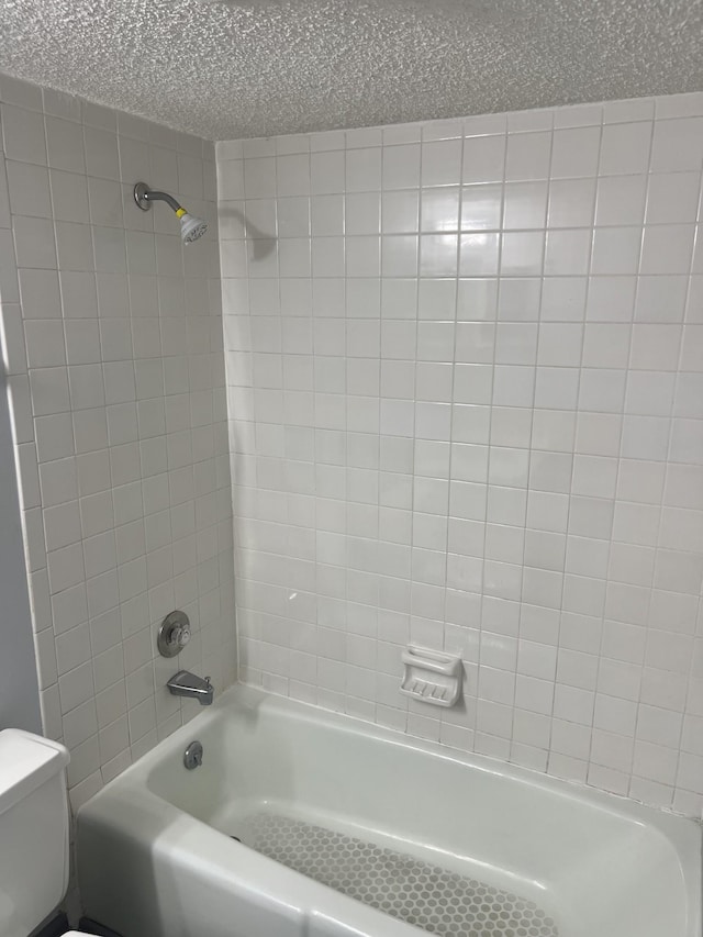 bathroom with tiled shower / bath and toilet