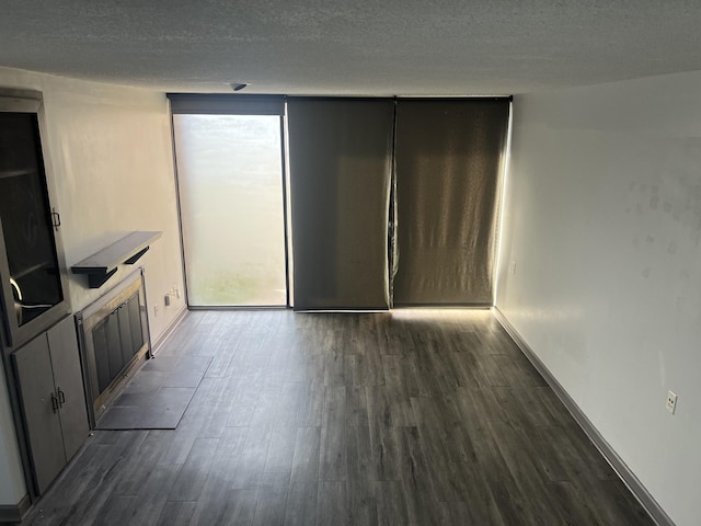 interior space with a textured ceiling and dark hardwood / wood-style flooring