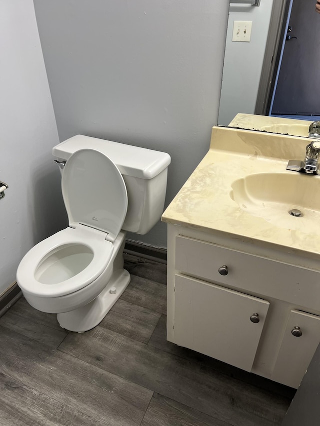 bathroom with vanity, toilet, and wood-type flooring