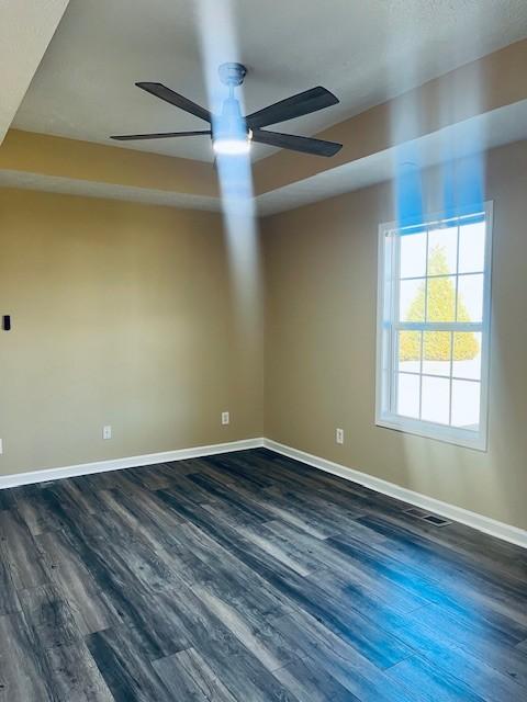 spare room with ceiling fan and dark wood-type flooring