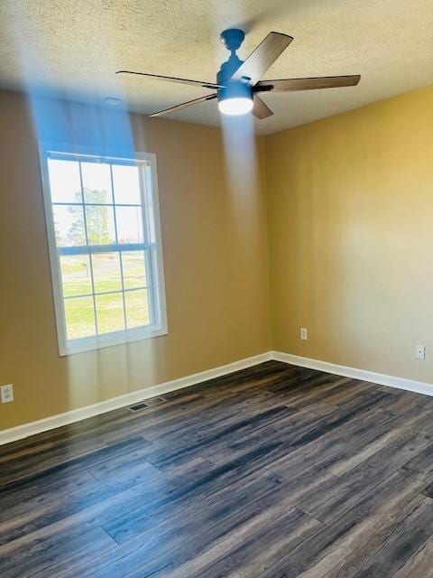 empty room featuring dark wood-type flooring and a textured ceiling