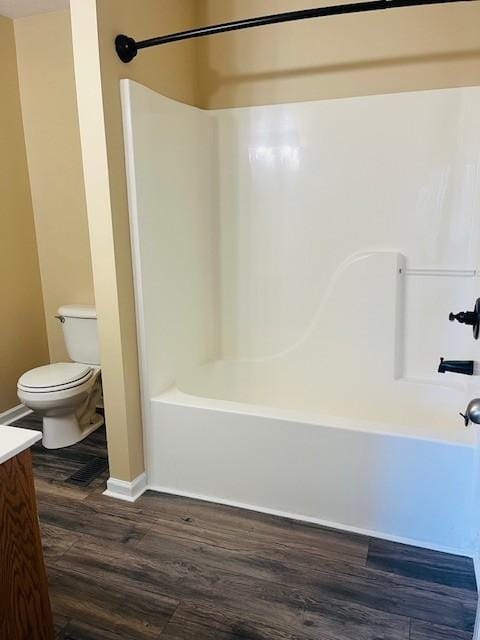 full bathroom with shower / tub combination, vanity, hardwood / wood-style flooring, and toilet